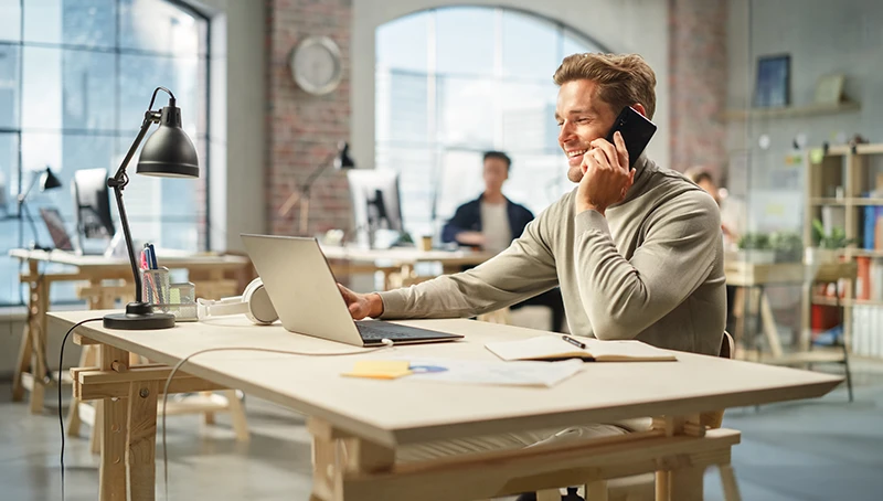 A person answering a mobile phone in an office
